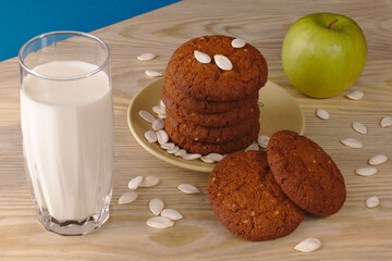 Daily healthy breakfast. Homemade oatmeal cookies, milk, fruit on wooden background.