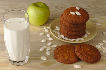 Daily healthy breakfast. Homemade oatmeal cookies, milk, fruit on wooden background.