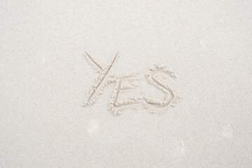 Concept: YES word on white clean sand.