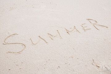 Concept: SUMMER word on white clean sand.