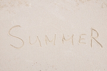 Concept: SUMMER word on white clean sand.