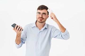 Photo of thinking man in eyeglasses holding cellphone and credit card