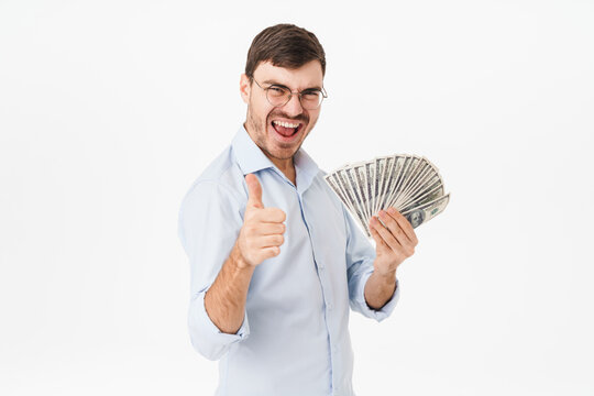 Photo of delighted man holding dollars and showing thumb up