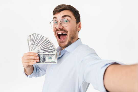 Photo of delighted man holding dollars and taking selfie photo
