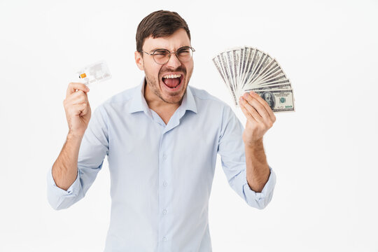 Photo of delighted man holding dollars and credit card while screaming