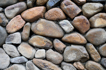 Wall background of rural buildings paved with large cobblestones