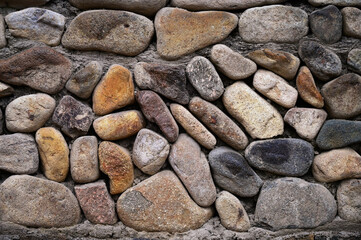 Wall background of rural buildings paved with large cobblestones