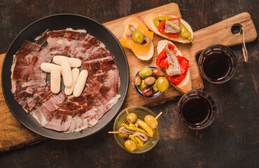 Spanish tapas with jamón ibérico or cured ham, olives, anchovies, wine. Typical spanish appetizers copy space. 
