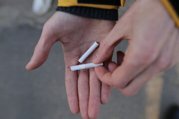 A man holds a broken cigarette in his hand. smoking cessation image. Get rid of bad habits.
