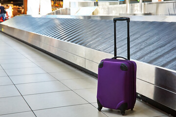 suitcase standing near empty conveyor belt at baggage claim at airport. - 355184950
