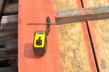 Construction roulette lies on wooden boards, construction work.