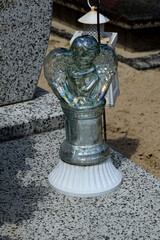 a plastic candle in the shape of an angel in the cemetery