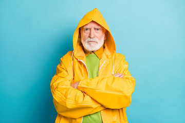 Close-up portrait of his he nice serious grey-haired man fisherman wearing yellow overcoat folded...
