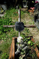 destroyed old wooden grave with an old metal cross