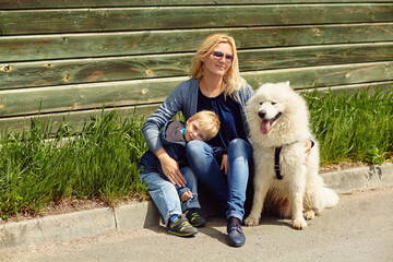 outdoor portrait mother, son and dog. child and mom walking samoyed laika.