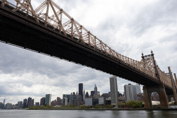 Queensboro Bridge along the East River with the Midtown Manhattan Skyline in New York City on a Cloudy Day