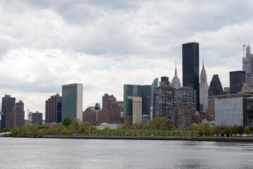 Fototapeta na wymiar Midtown Manhattan Skyline along the East River in New York City with a Cloudy Sky
