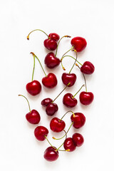 Fototapeta na wymiar Scattered cherry berries on a white background vertical orientation
