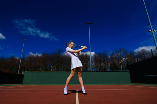Happy beautiful sexy girl playing tennis on the court. Sport and recreation, leisure