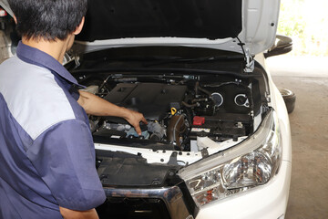 The mechanic is checking the engine.