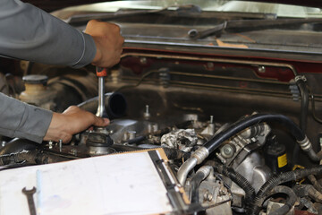 The mechanic is checking the engine.