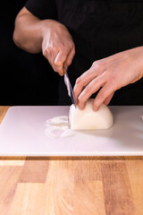 Fototapeta na wymiar female hands cutting onion with a knife