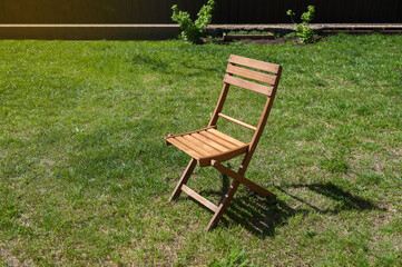 wooden chair in the garden on a background of green lawn