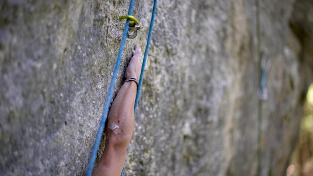 Close-up of rock climber reaching and gripping hold during climb