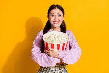 Portrait of candid funny crazy teen girl hold embrace big pop corn box while watching series wear checkered pullover isolated over bright shine color background