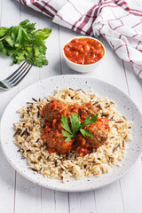 Beef meatballs and brown rice on a plate. Ready made portioned dish meat with garnish.