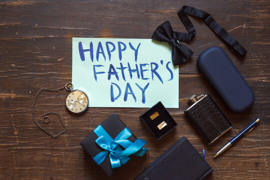 happy father's day card and stylish men's accessories on wooden background, top view