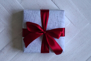 square gift box tied with a red satin ribbon