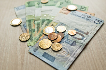 Belarusian rubles and coins on a colored background