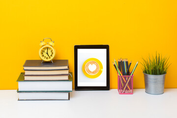 Tablet mockup with School equipment on yellow background.