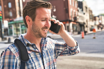 portrait of a trendy young man in the city walking and speak on the phone