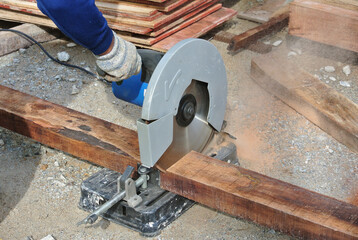 MALACCA, MALAYSIA -APRIL 25, 2016: Carpenter using the electrically powered circular saw to cut plywood at the construction site in Malacca, Malaysia. 