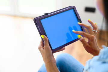 Back view female hands hold a digital tablet computer with a blank screen. Copy space for text, mock-up
