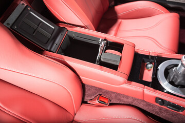 Close up of red leather car interior with storage space under the arm rest