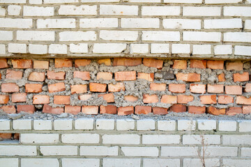 texture of a white brick wall with a red brick stripe on it