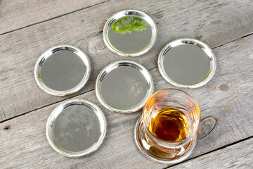 Antique silverplated coasters on wooden background.