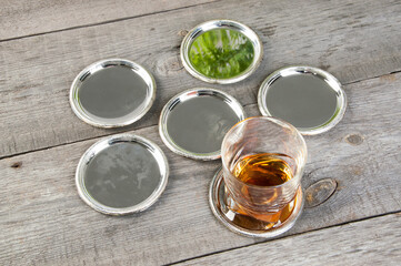 Antique silverplated coasters on wooden background.