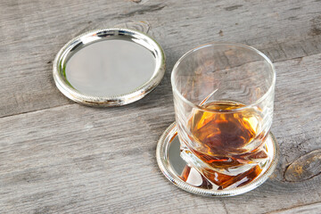 Antique silverplated coasters on wooden background.