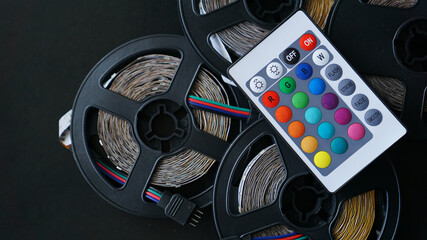 Three Led strip coils closeup. Diode with control panel for switching colors on dark background.