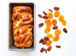Traditional French viennoiserie yeast bread (brioche) with nuts and dried apricots. Brioche is in a...