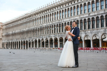 Obraz premium Happy beautiful wedding couple posing in venice square