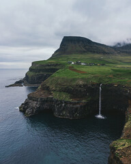 Mulafossur waterfall in the Faroe Islands. Beautiful waterfall that falls into the ocean near the village of Gasadalur.