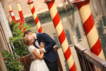Fototapeta na wymiar Beautiful wedding couple posing near dock in venice