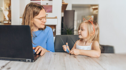 mother and daughter together at home on the computer