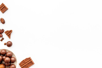 Chocolate background on white table top-down frame. Sweet desserts concept. Copy space