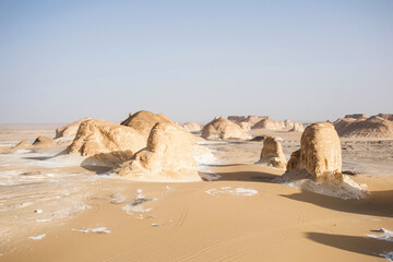 Fototapeta na wymiar Desert landscape with rock formations and sand dunes. panoramic view of the white desert in Egypt. Travel scene. 
